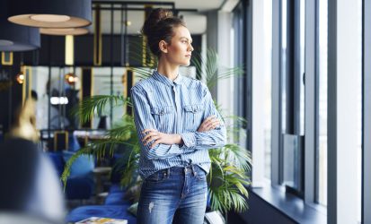 focused-woman-looking-through-window-office (1)